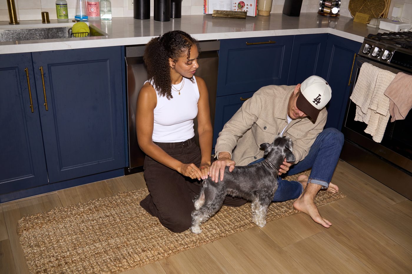 Sierra Obioha and Blake Robert sitting on a kitchen floor with Bojangles